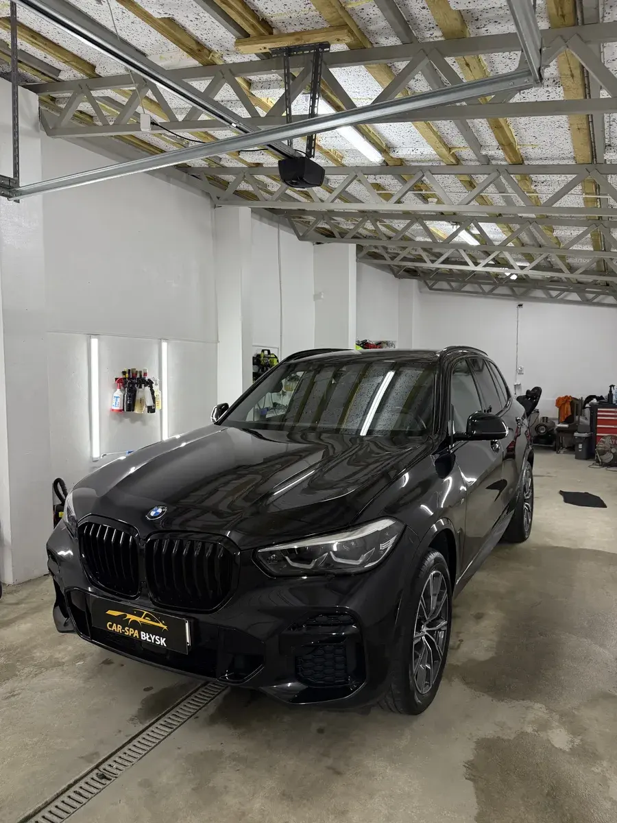Przód czarnego BMW X5 w hali